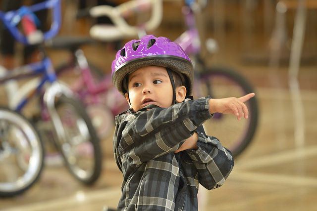 Young cyclist pointing at a bike